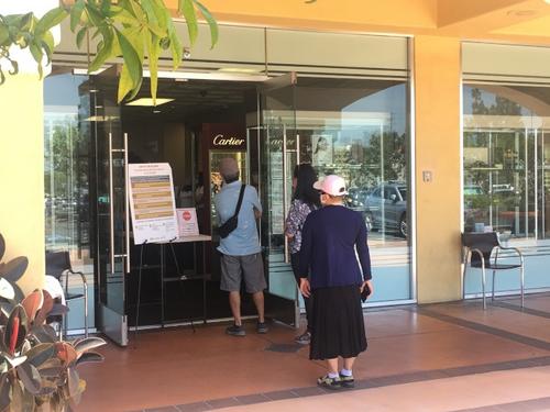 中國僑網(wǎng)店家為客人測量體溫。(美國《世界日?qǐng)?bào)》/王全秀子 攝)