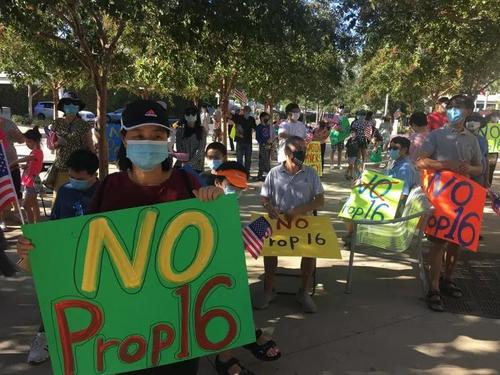 中國(guó)僑網(wǎng)民眾手持反對(duì)16號(hào)提案的標(biāo)牌。(圖片來(lái)源:美國(guó)《世界日?qǐng)?bào)》/王全秀子 攝)