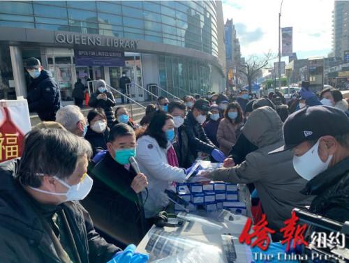 中國僑網(wǎng)華商會向法拉盛民眾派發(fā)口罩等防疫物資。(美國《僑報》/張晶 攝)