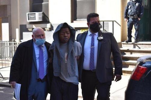 中國僑網(wǎng) 納許(中)14日被押出市警五分局,身上衣服上還有血跡。(記者顏嘉瑩/攝影)