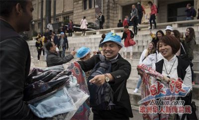 兩名游客在商販?zhǔn)种匈徺I假冒偽劣商品。