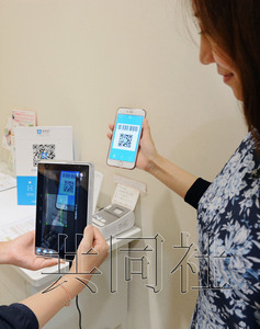 圖為位于大阪的近鐵百貨店總店用平板終端掃描二維碼。(日本共同社)