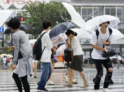 圖為在臺風(fēng)“蒲公英”強(qiáng)風(fēng)中緊持雨傘步行的人們。8月22日下午攝于東京澀谷。(日本共同社)