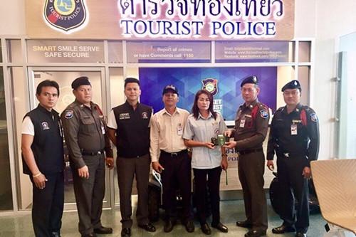 中國(guó)僑網(wǎng)女司機(jī)將錢(qián)包交到警察手中。(泰國(guó)《世界日?qǐng)?bào)》)