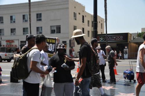 中國(guó)僑網(wǎng)好萊塢星光大道上,幾個(gè)賣(mài)光盤(pán)的小販將一位中國(guó)游客(前左)圍住。(美國(guó)《世界日?qǐng)?bào)》/張?jiān)?攝)