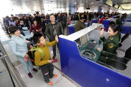 中國僑網(wǎng)資料圖:邊檢站民警為出境游返程的旅客辦理通關(guān)手續(xù)。新華社發(fā)