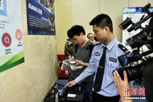 中國僑網(wǎng)資料圖:警方演示出入境證件移動(dòng)服務(wù)辦證機(jī)工作流程。中新社記者 陳驥旻 攝