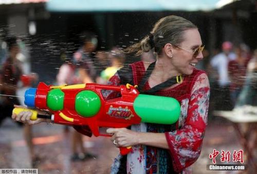 中國(guó)僑網(wǎng)資料圖:曼谷街頭的游客在潑水節(jié)上開心地玩水。