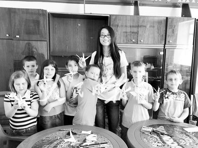 王思迪(中)和孩子們展示折紙作品。