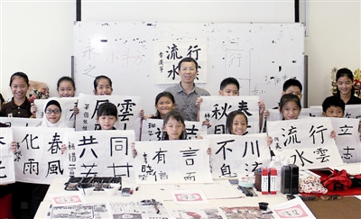 營員高興地展示書法成果。記者