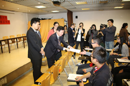 中國(guó)僑網(wǎng)雷振剛為參加大賽的學(xué)生發(fā)放試卷。(法國(guó)《歐洲時(shí)報(bào)》/黃冠杰 攝)