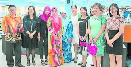 中國僑網(wǎng)周福仁(左起)陪同劉叢及其他來賓參觀校園,并與辦公室內(nèi)的巫裔教師交流。(馬來西亞《星洲日報(bào)》)