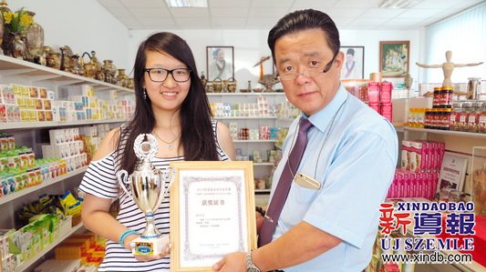 匈牙利東方國藥集團董事長陳震博士（右）為楊可欣（左）頒發(fā)榮譽證書。（匈牙利《新導(dǎo)報》）