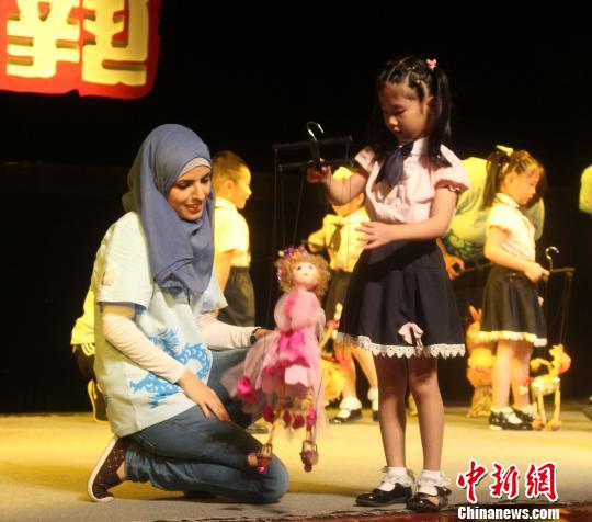 圖為泉州小朋友細(xì)心教授選手提線木偶?！×戊o　攝
