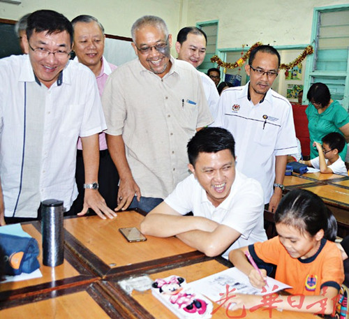 張盛聞(坐者左)為正在練習作業(yè)的小六考生加油打氣
