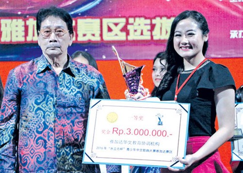 雅加達華文教育協(xié)調(diào)機構(gòu)輔導委員會常務(wù)主席楊健強(左)為一等獎獲得者方馨楦(右)頒獎