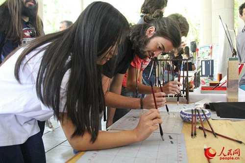 里約孔院中國日活動現(xiàn)場,孔院教師進(jìn)行中國書法現(xiàn)場教學(xué)。