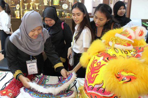 中國僑網(wǎng)文化展臺前多國師生欣賞精湛的工藝飾品