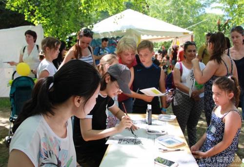 中國僑網(wǎng)志愿者為當(dāng)?shù)貎和瘯鴮懼形拿帧? /></div><!--圖片--><!--圖片說明-->
<div id=