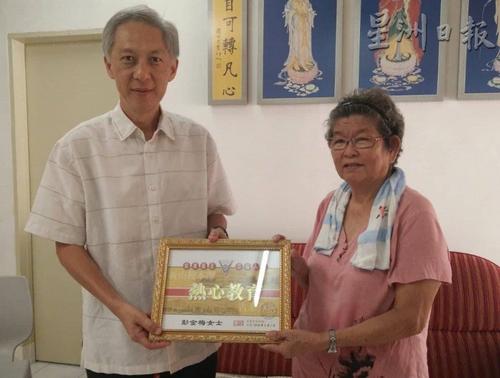 中國僑網(wǎng)童星存(左)代表寬柔中學(xué),贈送感謝狀予彭金梅。(圖片來源:馬來西亞《星洲日報》)