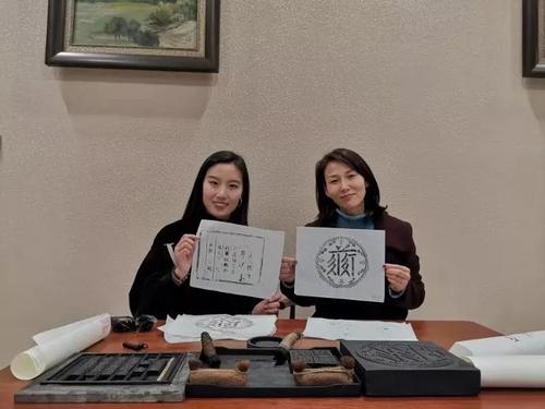 中國僑網(wǎng)外景老師毋典和王華瑞老師(右)示范印刷術(shù)的操作方式(圖片來源:中國華文教育基金會)