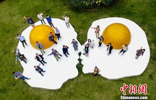 中國僑網(wǎng)航拍海外華文媒體代表參觀武漢東湖綠道在藝術(shù)景觀前合影 鄭子顏 攝