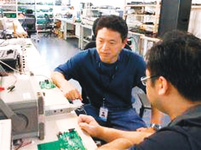 中國僑網圖為向毅海(左)在工作。(《人民日報海外版》)