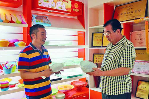 圖為企業(yè)負(fù)責(zé)人正在向顧客介紹最新研發(fā)的“仿玉”系列密胺餐具。(方薇