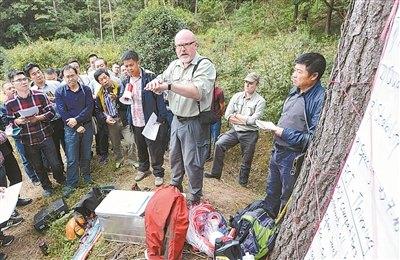 中國僑網(wǎng)德國專家現(xiàn)場講解演示近自然林經(jīng)營及目標(biāo)樹單株撫育方法。(記者 徐能 攝)