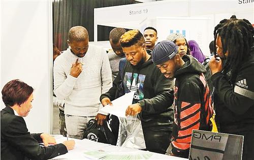 中國僑網(wǎng)求職者在企業(yè)展臺前咨詢(《經(jīng)濟(jì)日報(bào)》/鄭彤彤 攝)