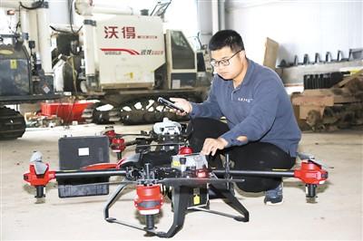 中國僑網(wǎng)丁旦正在手機上調(diào)試無人機。(圖片來源:《人民日報海外版》)