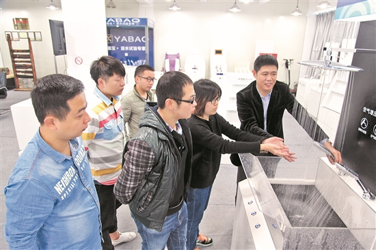 中國(guó)僑網(wǎng)洪長(zhǎng)明(右一)演示“試水臺(tái)”的用法