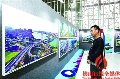 中國僑網(wǎng)一位市民駐足觀看航拍照片。/佛山日報(bào)記者 王澍攝