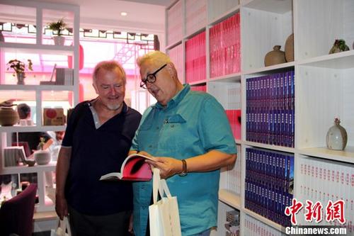 中國僑網(wǎng)資料圖:外國友人在驛站內(nèi)翻看《情調(diào)蘇州》書籍。中新社發(fā) 黃梅 攝