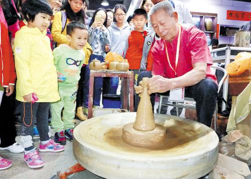 中國(guó)僑網(wǎng)資料圖:黃樹(shù)藩現(xiàn)場(chǎng)展示手拉朱泥壺陶藝 (來(lái)源:羊城晚報(bào))