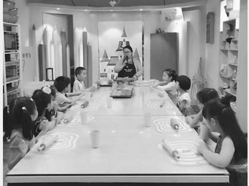 中國僑網(wǎng)詹雅戎(中)在教孩子們DIY糕點。