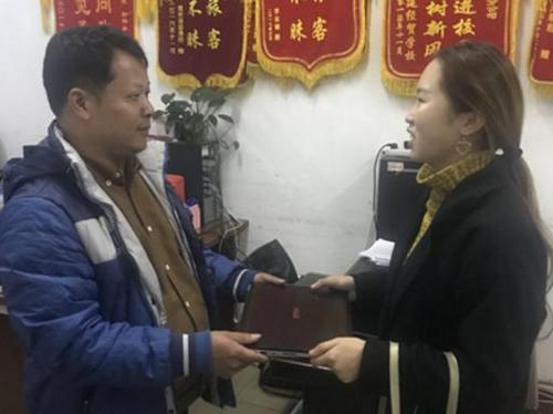 中國僑網(wǎng)駕駛員梁師傅將失物交給失主小余