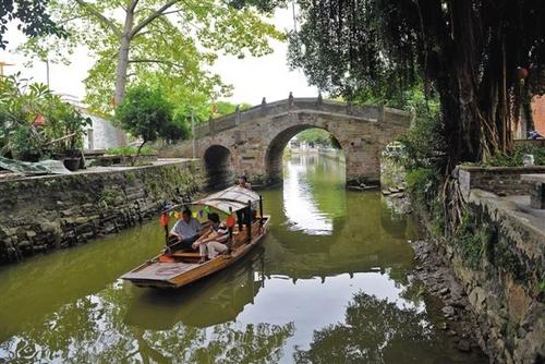 中國(guó)僑網(wǎng)逢簡(jiǎn)水鄉(xiāng),游客乘小船石橋。 羊城晚報(bào)記者 林桂炎 攝