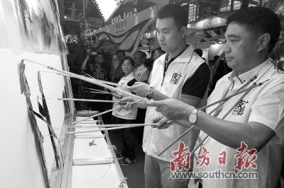 中國僑網(wǎng)蔡勁筍(右一)在文博會主會場大鵬展區(qū)表演皮影戲。 南方日報記者 朱洪波 攝