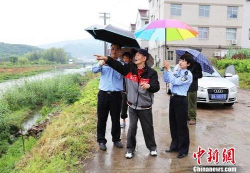 中國僑網圖為:民警陪臺胞蔣志凡尋找其父親86年前的安葬地 仙居公安供圖