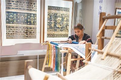 中國僑網(wǎng)黎族織錦藝人展示龍被織繡場景。 本報記者 宋國強 攝