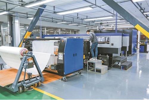 中國僑網(wǎng)溢達公司工人在使用智能化設(shè)備工作