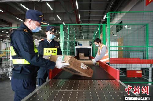 中國(guó)僑網(wǎng)拱北海關(guān)所屬港珠澳大橋海關(guān)關(guān)員在港珠澳跨境電商作業(yè)中心驗(yàn)放包裹 樊詩(shī)如 攝