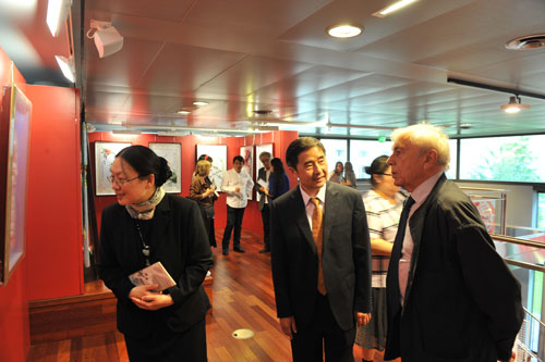 中國民間藝術(shù)家協(xié)會負(fù)責(zé)人羅揚(yáng)(中)向法蘭西學(xué)院藝術(shù)院主席克洛德-阿巴及(右)介紹作品。(法國《歐洲時(shí)報(bào)》/吳鋼