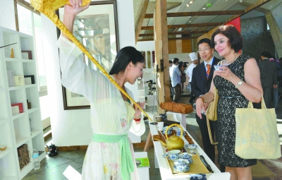 中國僑網(wǎng)身著傳統(tǒng)漢服的茶藝師王霏向外國朋友展示茶藝。(張全能 攝)
