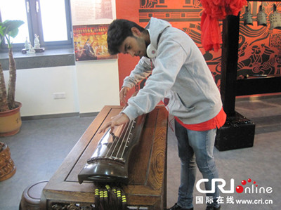 中國僑網(wǎng)團(tuán)員體驗(yàn)中國古代樂器。(廖亮 攝)