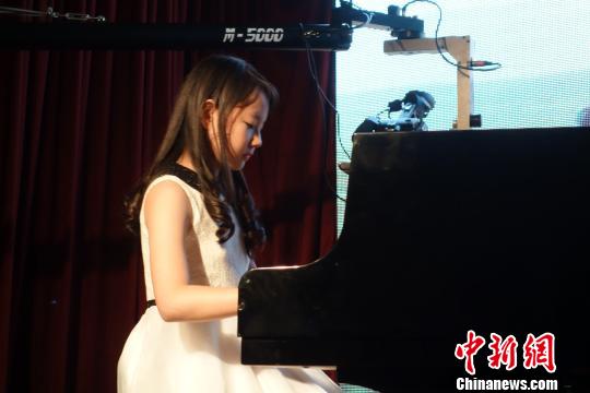 中國(guó)僑網(wǎng)圖為華裔少女王逸心在演奏。莫成雄 攝