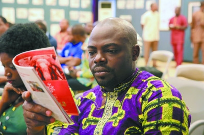 中國(guó)僑網(wǎng)貝寧媒體記者認(rèn)真閱讀“歡樂春節(jié)”宣傳冊(cè)。(曹肅 攝)