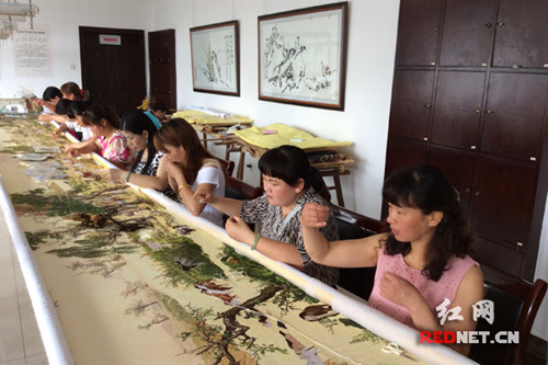 中國僑網(wǎng)《百駿圖》奔赴米蘭前夕,江再紅(右起第四)帶領(lǐng)繡工們刺繡