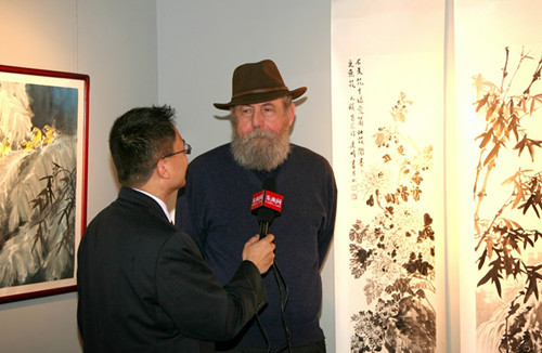 中國僑網(wǎng)美國藝術(shù)家贊嘆中國畫家的牡丹國畫作品。(李亞維 攝)